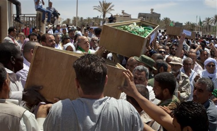 Mourners carry coffins during funeral for nine of 11 clerics allegedly killed in a NATO airstrike in Tripoli, Libya, Saturday, May 14, 2011. NATO said Saturday it cannot confirm the government's claim about the deaths. 